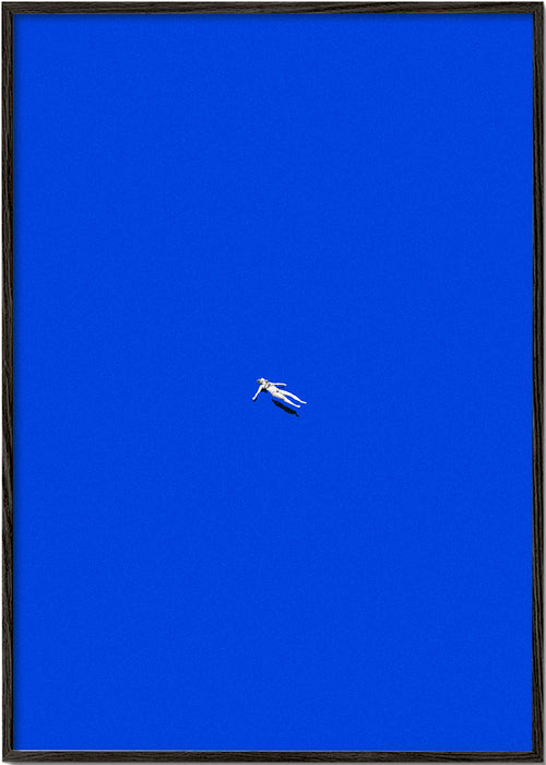 Minimalistisk plakat med svævende figur mod blå himmel