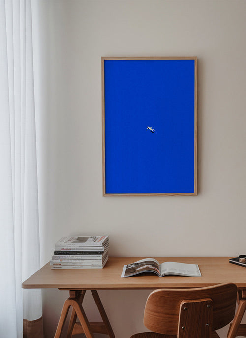 Minimalistisk plakat med svævende figur mod blå himmel