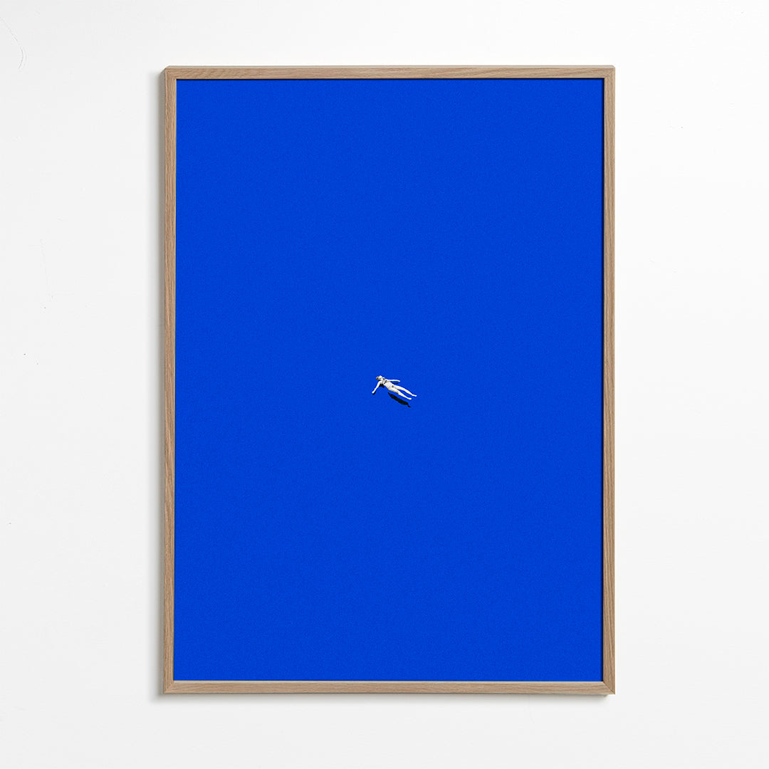 Minimalistisk plakat med svævende figur mod blå himmel