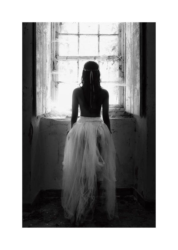 Fotografi figur set bagfra ved vindue