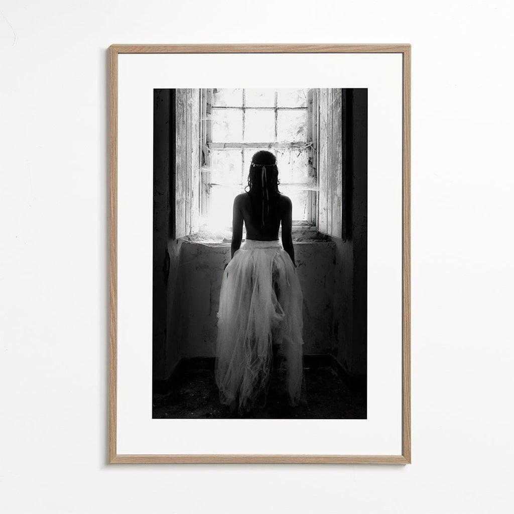 Fotografi figur set bagfra ved vindue