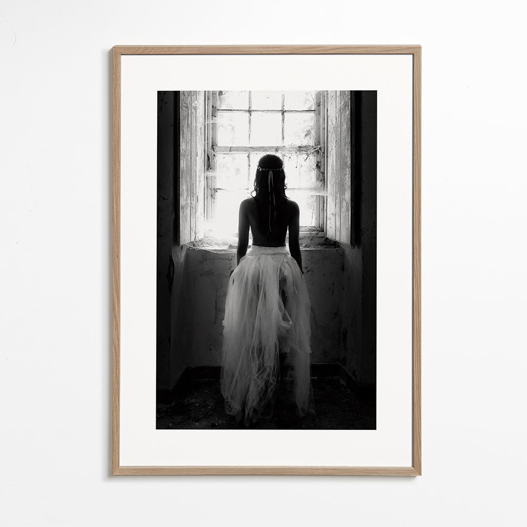 Fotografi figur set bagfra ved vindue