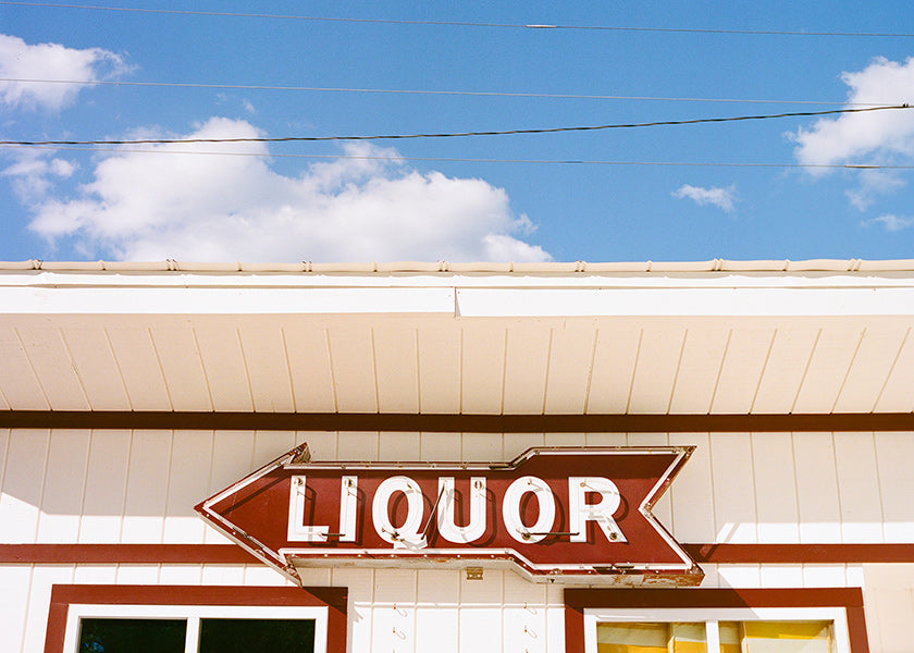 Vintage foto skilt 'LIQUOR' mod blå himmel