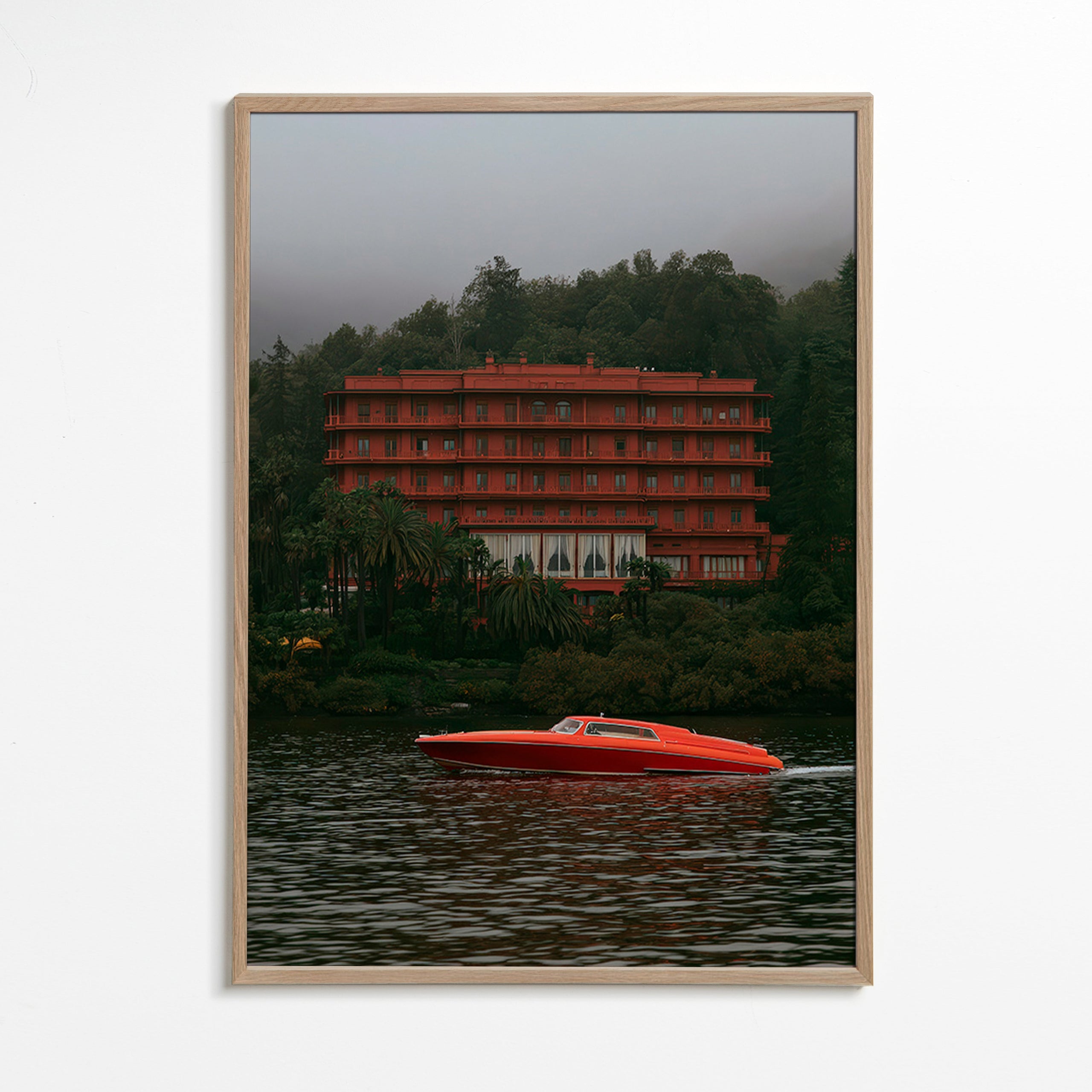 Landskabsbillede med rødt hotel og speedbåd